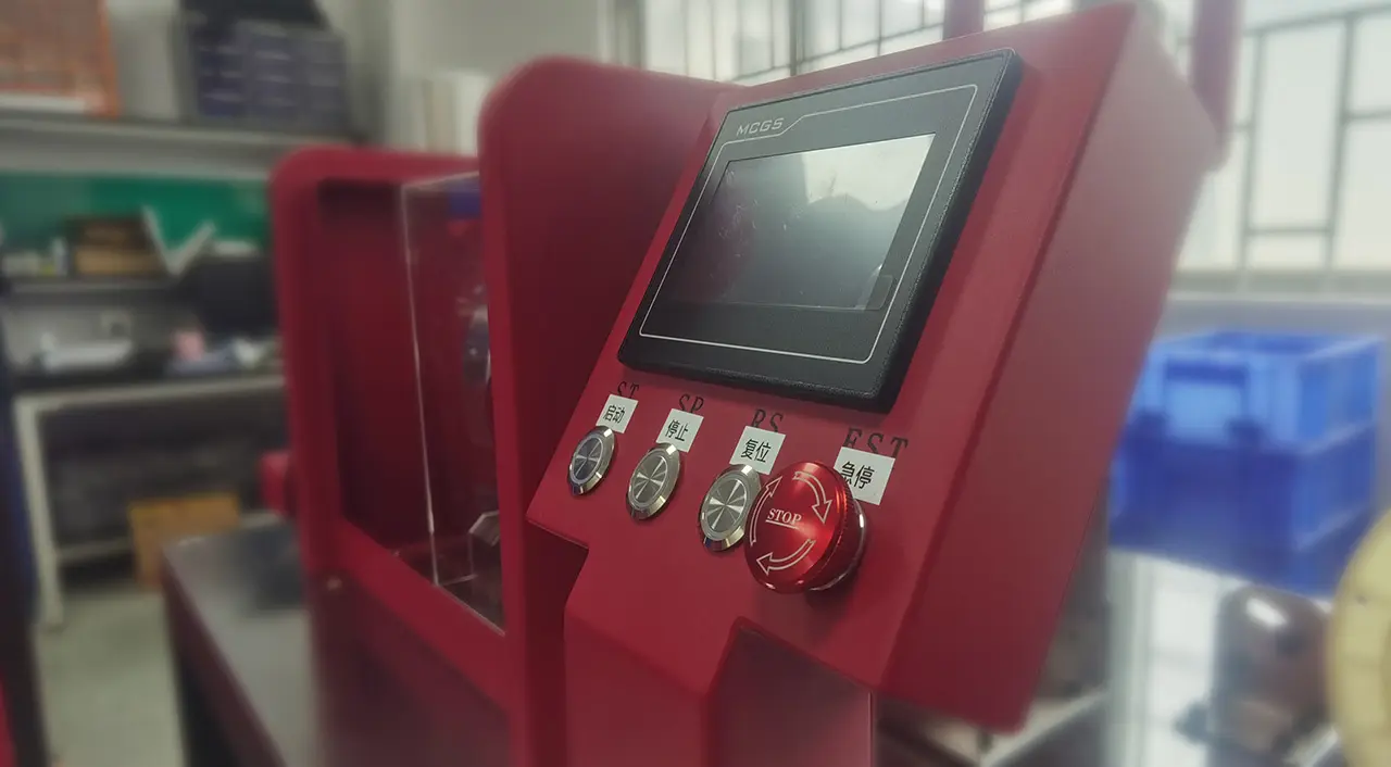 Close-up of red Sible jewelry machine control panel with MCGS touchscreen display, start-stop buttons, and emergency stop switch in factory setting